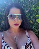 Fashionable woman in stylish leopard print top and designer sunglasses